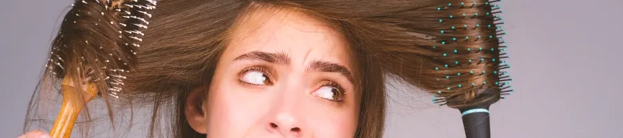 A woman with tangled hair on two hair brushes